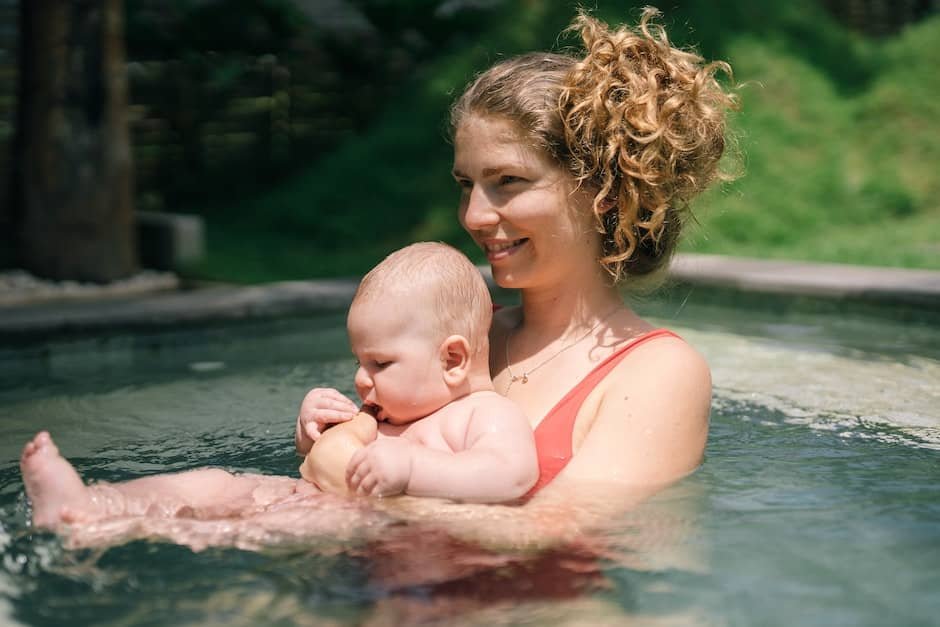 Mother Holding Her Baby in the Swimming Pool